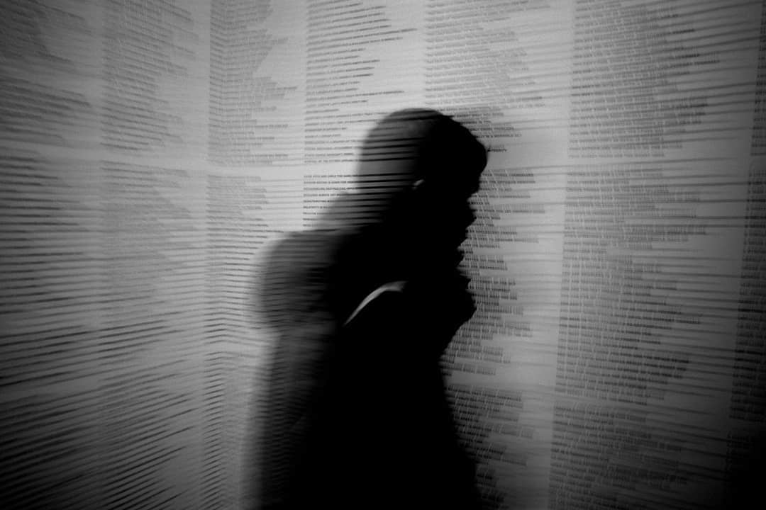 A blurred silhouette standing before a departure board