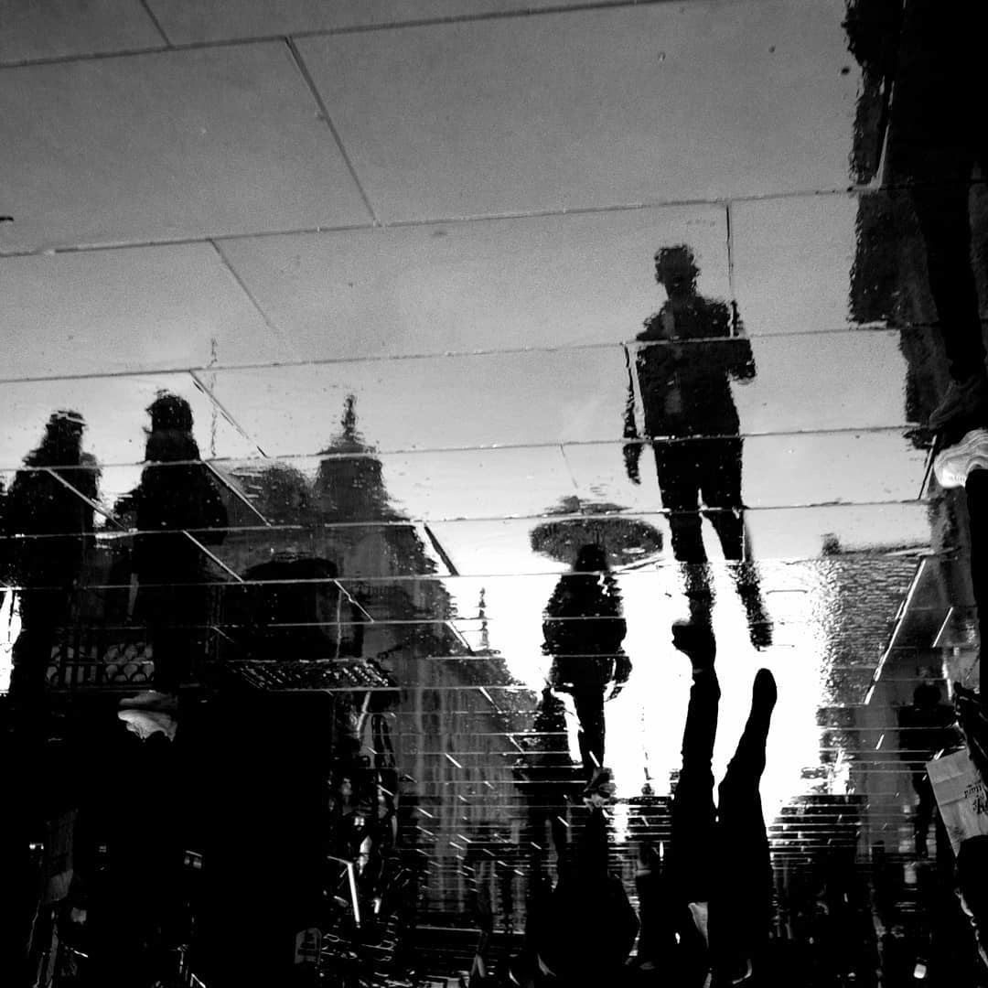 Figures reflected upside down on wet paving