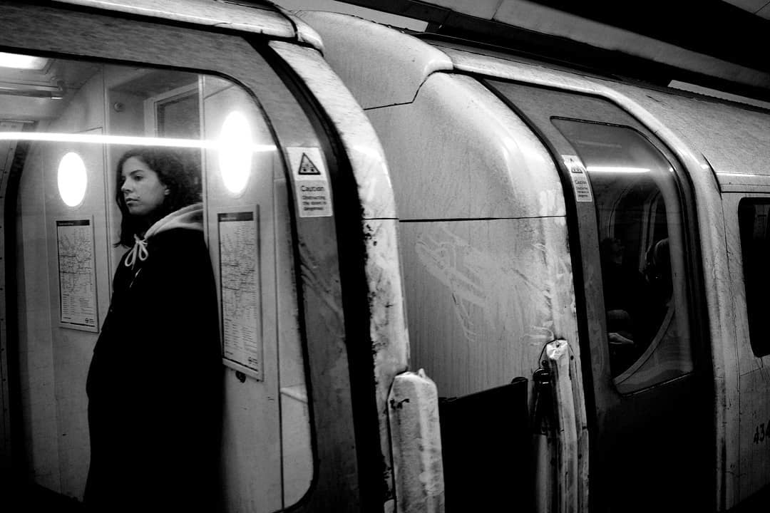 A commuter framed by open train doors