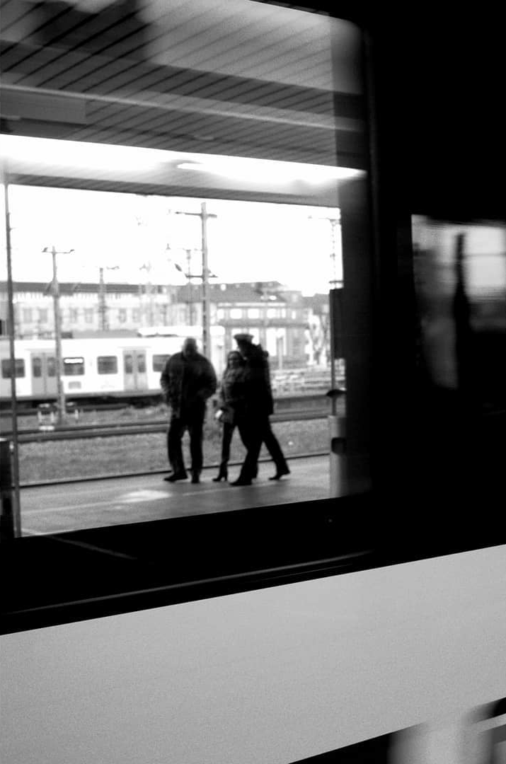 Two figures waiting on a station platform