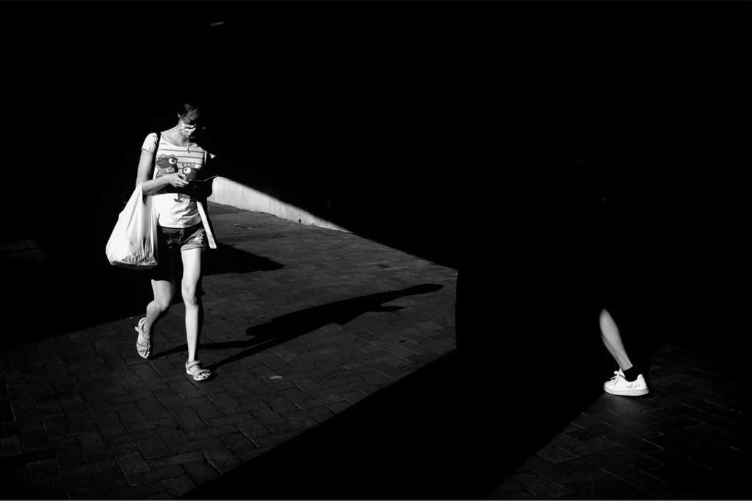 A figure walking through a sharply lit space